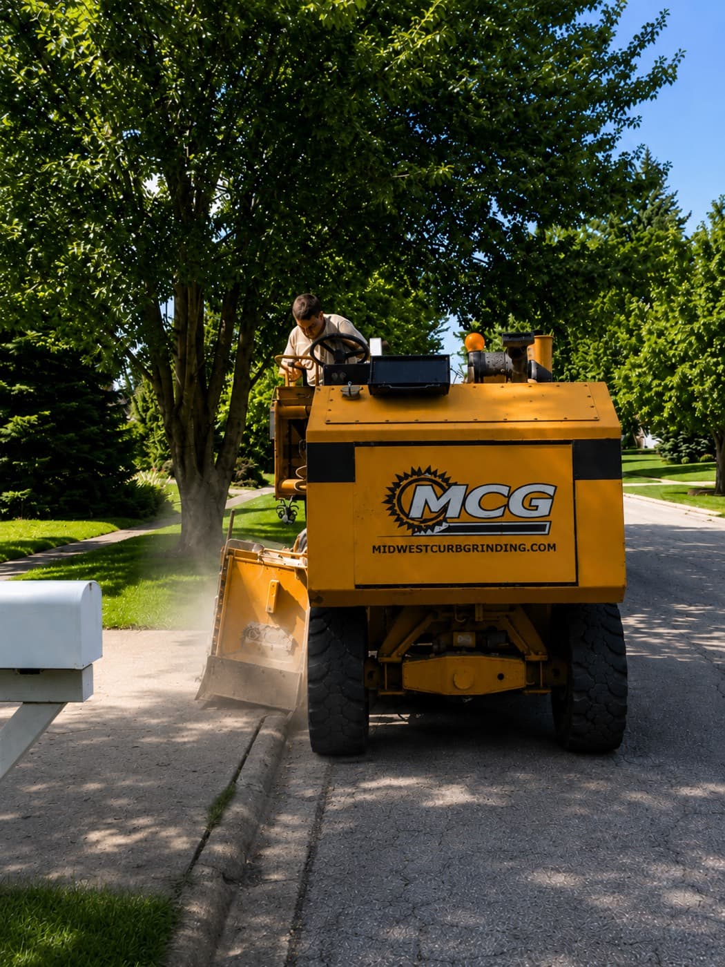 Midwest Curb Grinding machine grinding down a roll curb on a residential driveway in Iowa